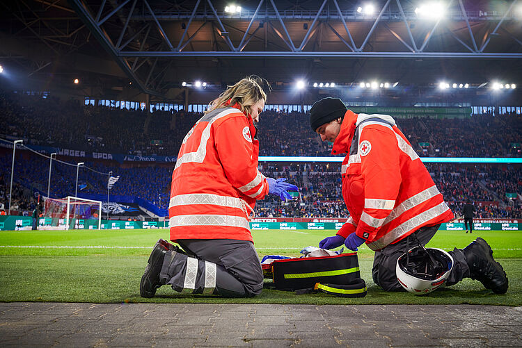 Sanitätsdienst Zwei Notfallsanitäter beim Einsatz in einem Fußballstadion.