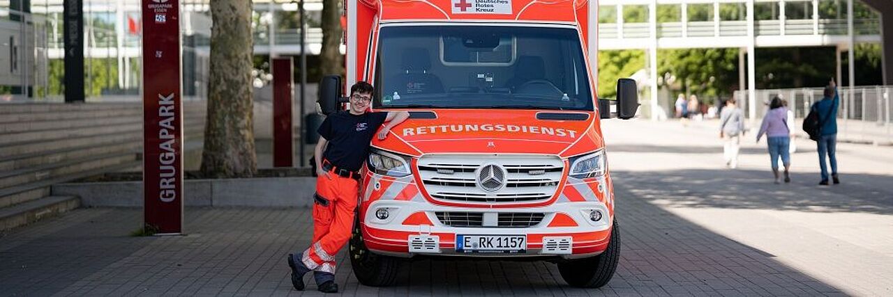 Ein Rettungshelfer lehnt sich an einen Rettungswagen.