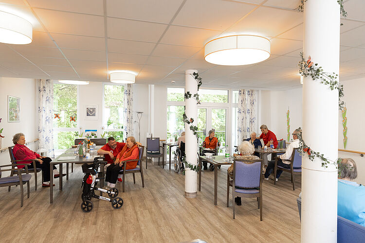 Pflegezentrum Solferino Im Aufenthaltsraum des Pflegezentrums Solferino sitzen mehrere Seniorinnen und Senioren an verschiedenen Tischen.