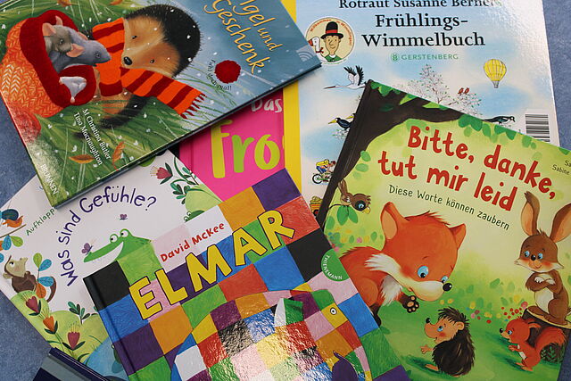 Zu sehen sind verschiedene Bilderbücher, die kreuz und quer übereinander liegen.