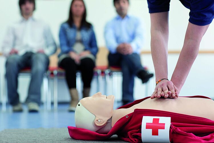 Erste Hilfe im Betrieb Hände machen die Herz-Lungen-Wiederbelebung an einer Puppe im Erste-Hilfe-Kurs