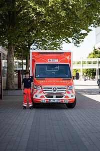 Sanitäter steht neben einem Rettungswagen vor dem Eingang des Grugaparks in Essen.