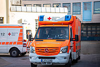 Ein Rettungswagen des DRK Essen fährt los mit Blaulicht. Im Hintergrund sind Gebäude sichtbar.